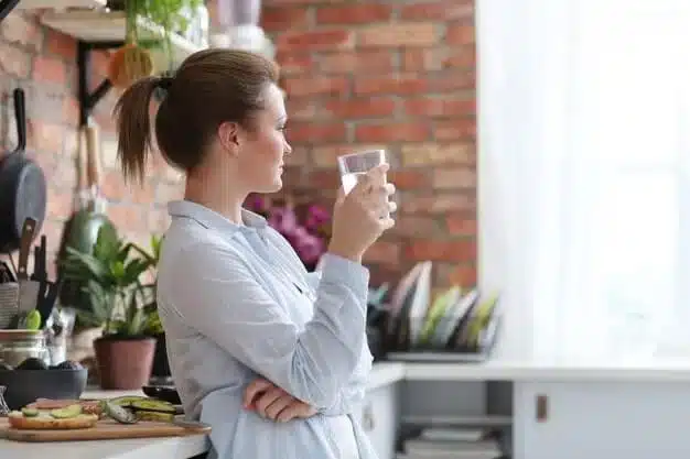 woman drinking water at home