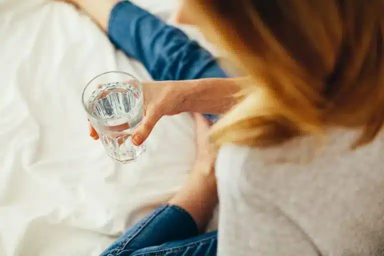 vrouw met een glas water in haar hand